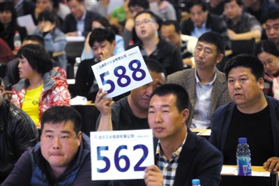 昨日，拍賣現(xiàn)場競拍者舉牌競拍。新京報記者