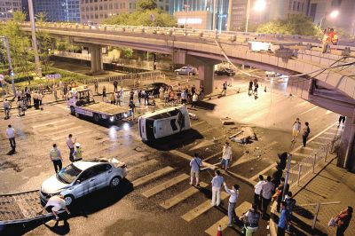 路虎沖下國貿(mào)橋砸中一輛起亞轎車，橋上厚達幾十厘米的水泥護欄被撞斷，碎石四處散落，數(shù)十群眾在現(xiàn)場圍觀。