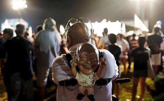 9月4日，新加坡，執(zhí)政黨的一場(chǎng)集會(huì)上，一名支持者背著一個(gè)李光耀的人偶。