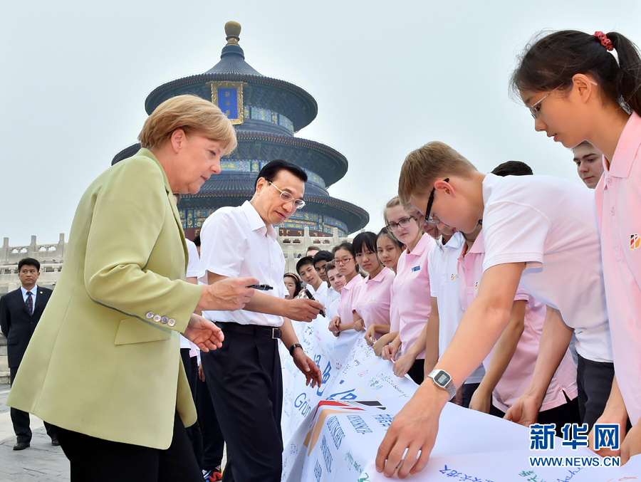 李克強同默克爾在紀(jì)念橫幅上簽名。