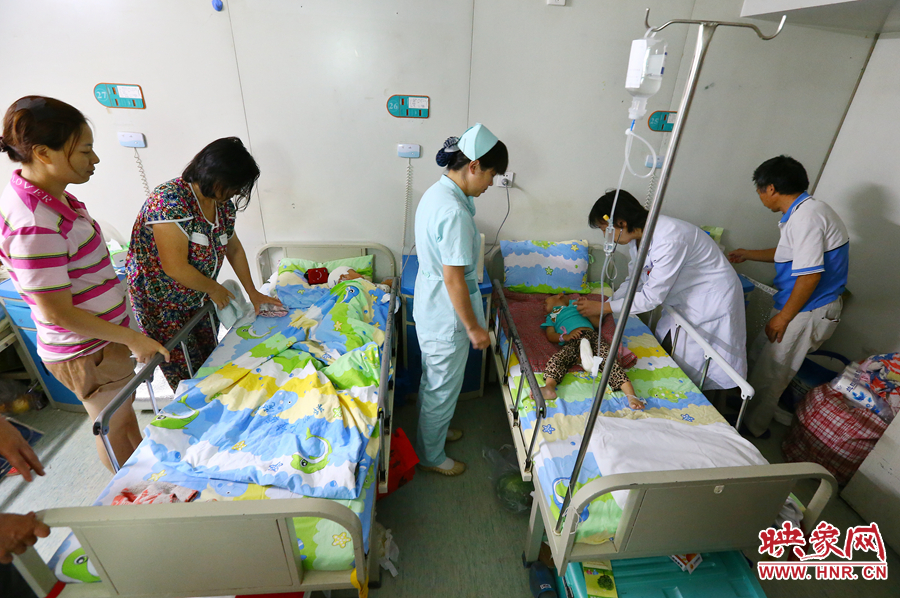 手術(shù)前，畫面右側(cè)的大龍正在接受醫(yī)生的檢查，左側(cè)的小龍還在熟睡。