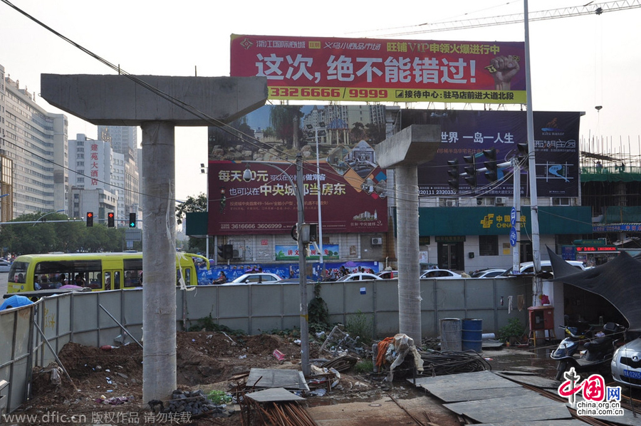 過街天橋一側(cè)的橋樁早已打好,可是對面的郵政銀行網(wǎng)點(diǎn)依舊在照常營業(yè)。