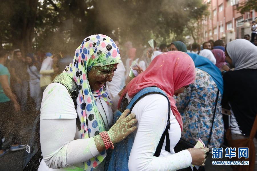 10月16日，在埃及首都開羅，兩名女青年在“彩色跑”活動中躲避人們拋撒的彩色粉末。