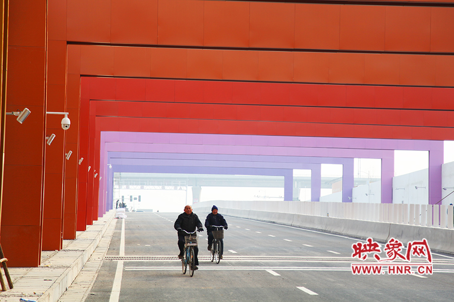 兩位老人騎自行車(chē)通過(guò)。