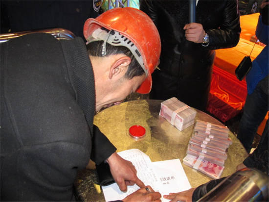 農(nóng)民工在現(xiàn)場(chǎng)領(lǐng)取工資。
