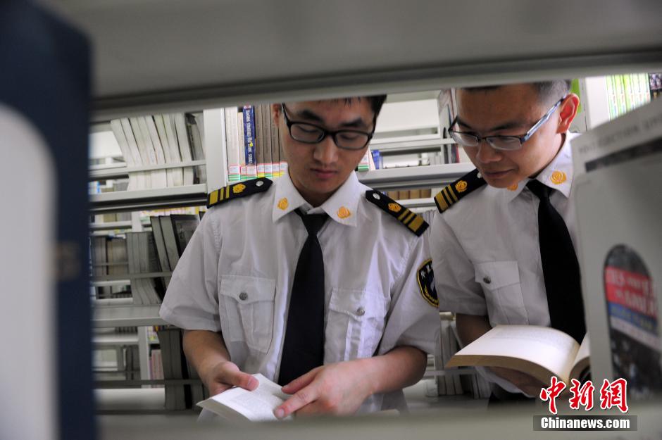 5月8日，武漢輕工大學(xué)圖書館保安吳濤與江力在圖書館交流學(xué)習。