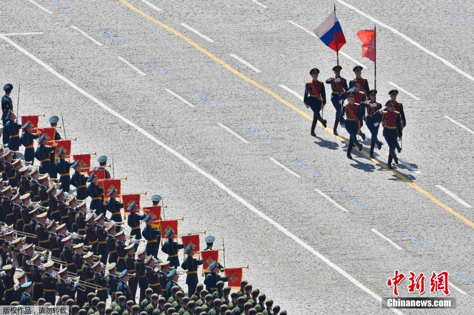 圖為俄羅斯國旗從受閱部隊前經(jīng)過。