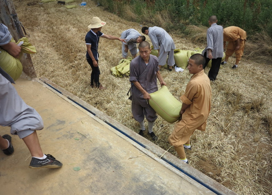 武僧將打包后的糧食集中至運(yùn)輸車輛上。