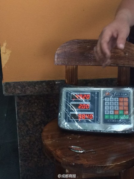 父子倆為大魚(yú)量體重。