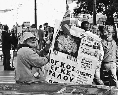 自債務危機爆發(fā)以來，希臘承諾實施以減薪、增稅、裁員和私有化為主要內容的緊縮和改革政策。一系列的緊縮措施使民眾生活受到嚴重影響，約1/4的家庭陷入貧困。圖為今年1月希臘大選期間，在雅典市中心國會大廈前廣場乞討的老人。