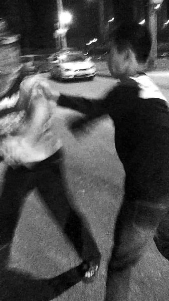 一名男子扯著民警的反光背心一路追打。