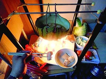 兩張椅子被面對面疊在一起，穿了兩根線的西瓜皮就懸空在椅腳中間，下面有蠟燭加熱，這就是西瓜火鍋。