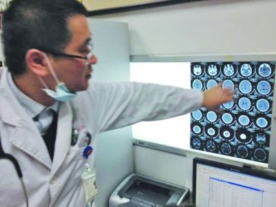 醫(yī)生在查看男孩的腦部CT片。薛馬義 攝