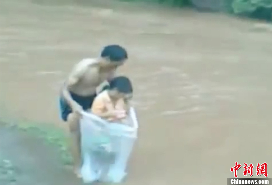 越南一村莊家長(zhǎng)用塑料袋運(yùn)孩子過河上學(xué) 越南一村莊家長(zhǎng)用塑料袋運(yùn)孩子過河上學(xué)