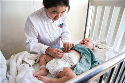 昨日，北京兒童醫(yī)院，護士為即將出院的被扎鋼針女嬰檢查傷口恢復情況。記者 高瑋 攝