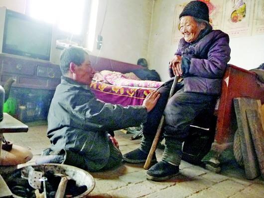 52歲的劉蘭山每天靠爬行照顧90歲的老母親。孫國祥 攝