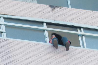 28樓的窗臺上坐著一名女子，其兩條腿耷拉在室外，不停地擺動。