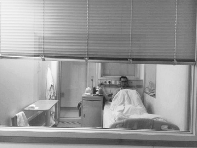 楊杰在醫(yī)院隔離病房中，沖記者揮了揮手。