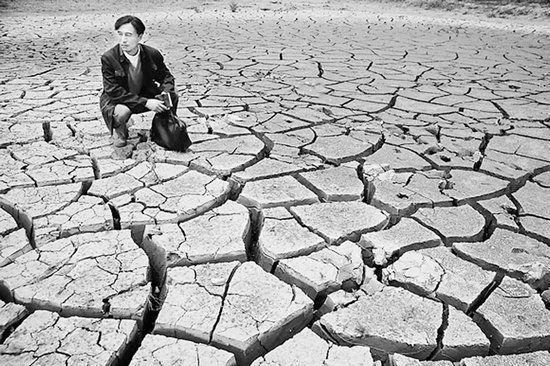 蹲在干涸的田地里，焦裕祿為饑餓的百姓揪心不已 《焦裕祿》劇照