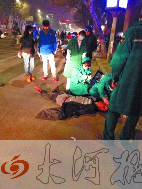 醉漢躺在地上，醫(yī)護(hù)人員對其進(jìn)行檢查。